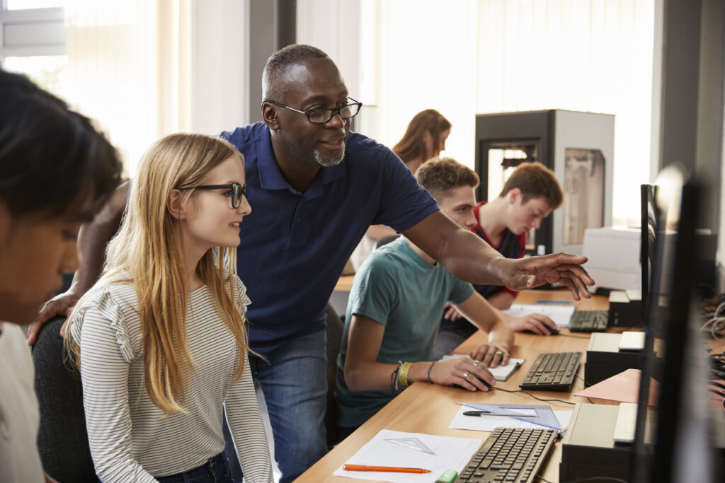 teacher helping students with computers in classro 2026 01 05 06 29 14 utc